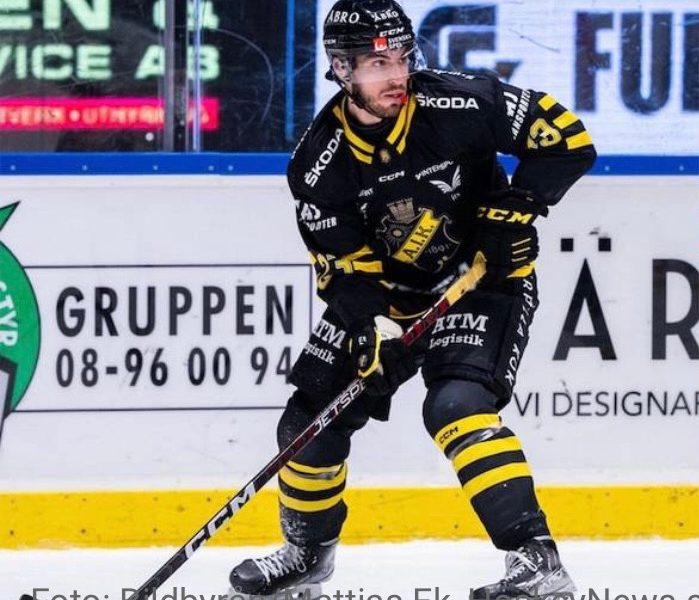 Image - Jake McGrew, is pictured in full ice hockey game wear, playing for his team.